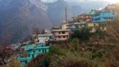 Emergency personnel and rescue vehicles deployed in a mountainous Himalayan valley in Uttarakhand