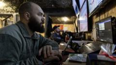 A Ukrainian soldier monitors a drone feed on a tablet connected to a Starlink satellite terminal near the front line