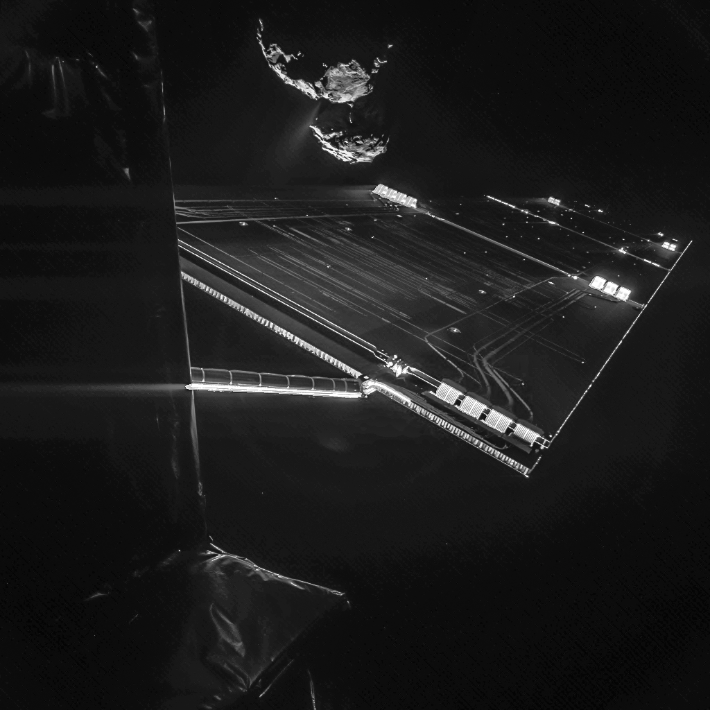Rosetta spacecraft solar array in space with the rugged double-lobed nucleus of Comet 67P in the background