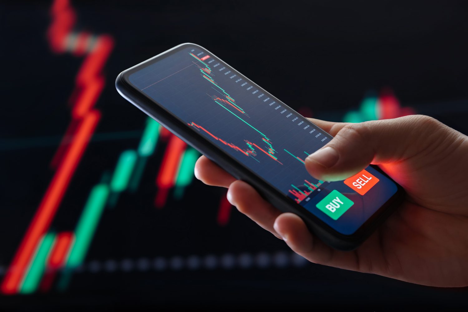 A financial tax document and calculator beside a digital screen displaying market trading charts.