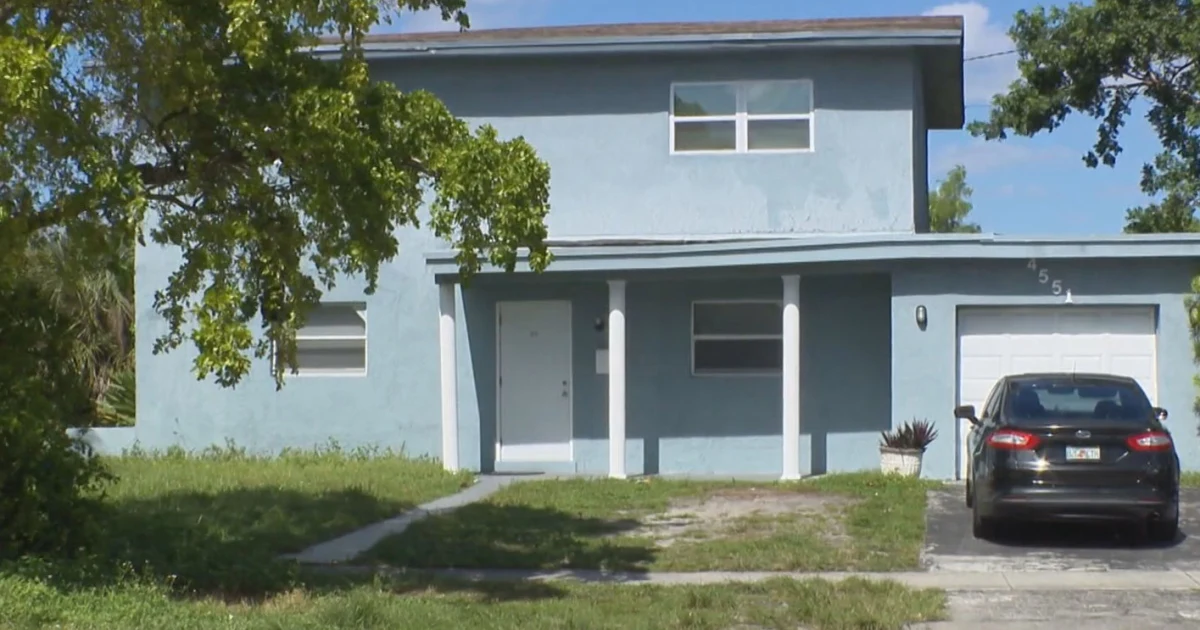 Exterior of a suburban South Florida residential home undergoing renovation behind property fencing.