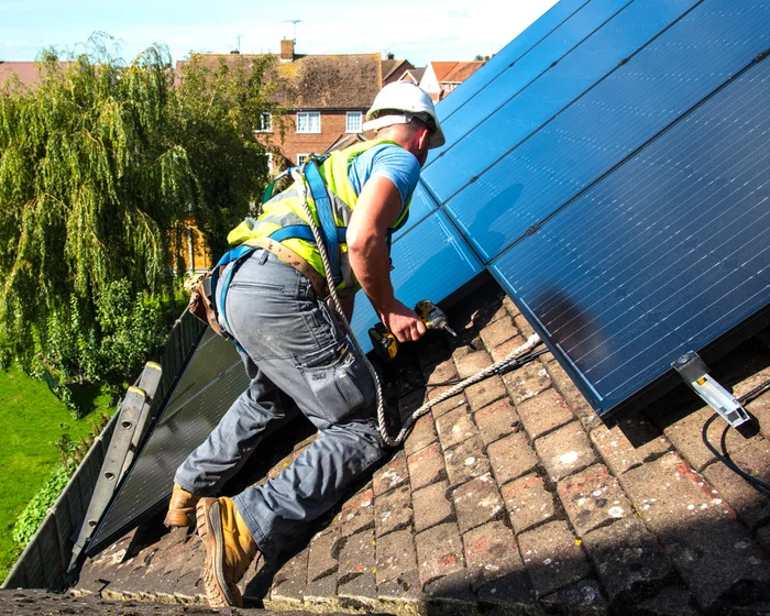 Rooftop solar panels and an outdoor heat pump unit at a home