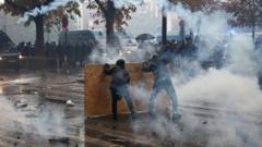Protesters and riot police face off on a street in Paris amid clouds of tear gas during France's second consecutive weekend of mass demonstrations