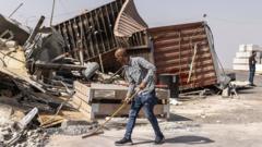 A man sweeps debris following Israeli demolitions in Hebron in the occupied West Bank