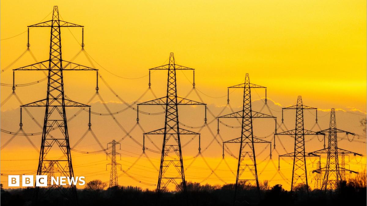 High-voltage electricity transmission pylons standing across a rural countryside landscape.