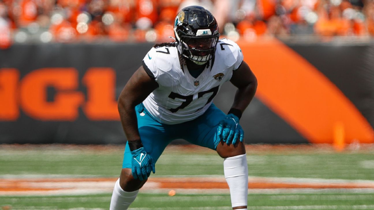 Jacksonville Jaguars offensive tackle Anton Harrison stands on the sideline in uniform during an NFL game.