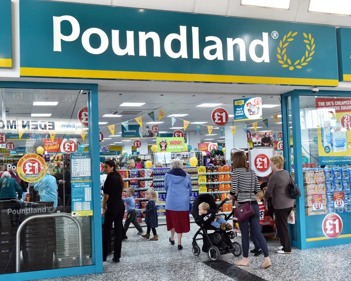 Shoppers at the entrance to a Poundland store with £1 price signs