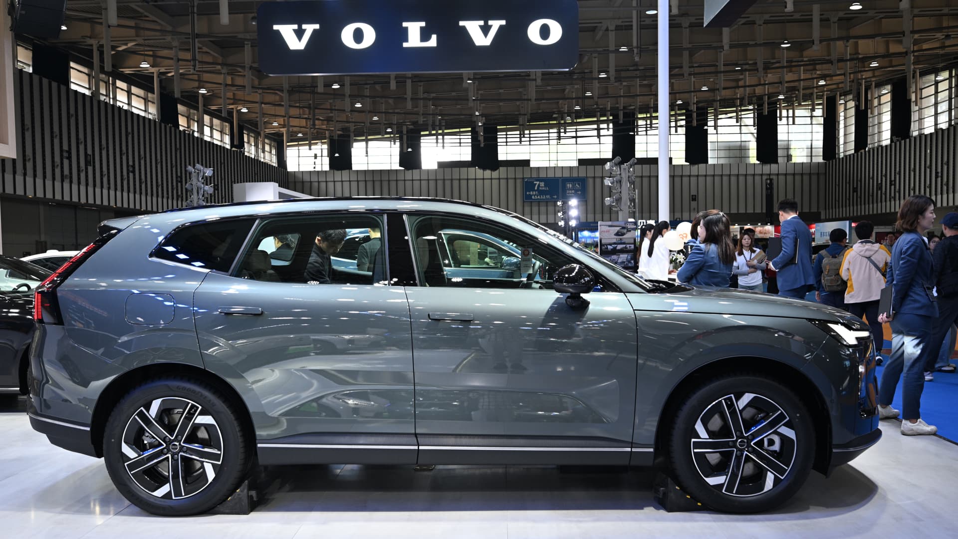 Exterior view of a Volvo Cars dealership showroom with corporate branding in the background.