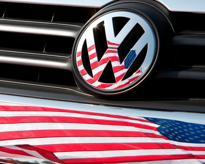 An American flag reflected in a Volkswagen badge and vehicle grille
