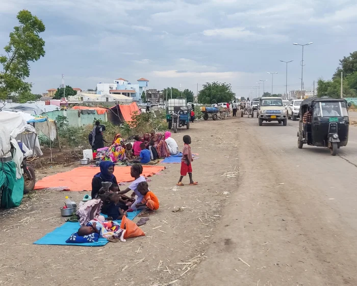 Displaced families gathered beside a road in Gedaref, Sudan