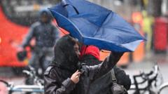 A person struggles with an overturned umbrella in wet and windy weather
