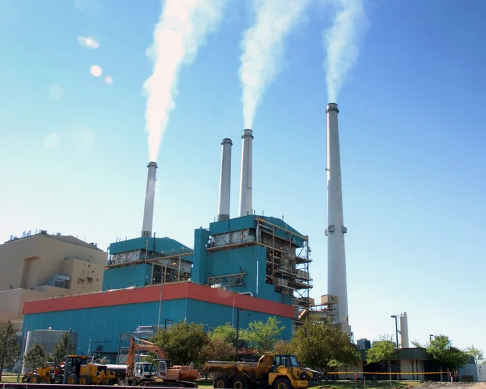 A large coal-fired power plant operating with steam rising from cooling towers