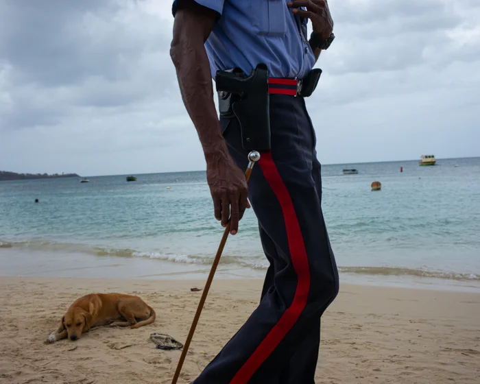A Grenadian police officer standing on a beach