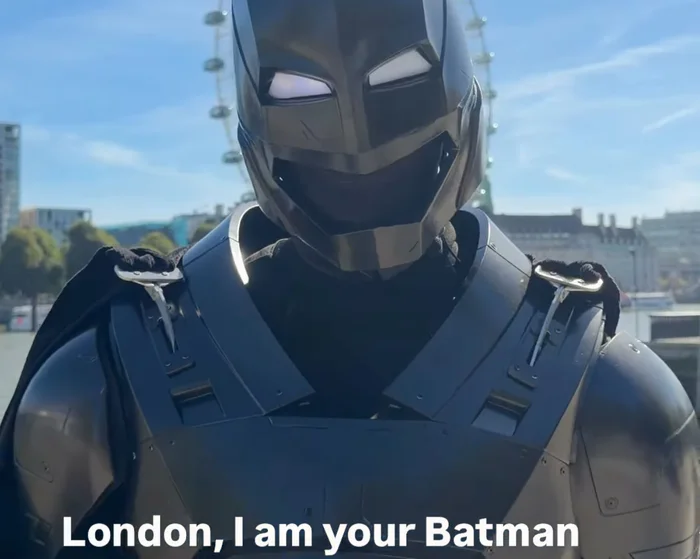 A costumed figure dressed as Batman cleaning city streets with volunteers