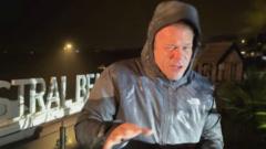 BBC weather presenter Simon King reporting in heavy winds along the Newquay coastline during Storm Austen.