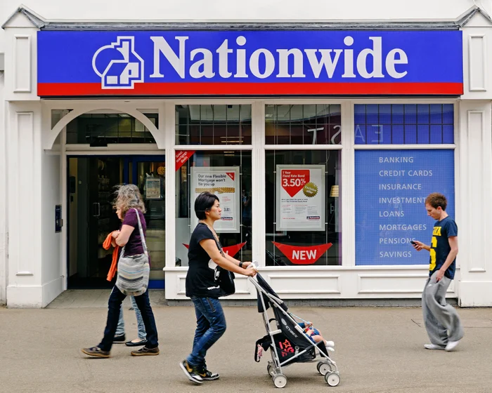 Pedestrians passing a Nationwide building society branch